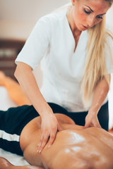 Obraz na płótnie Canvas Sports massage. Therapist massaging sportsman's back