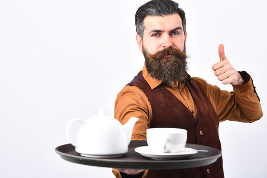 Barman with serious face serves tea showing super sign.