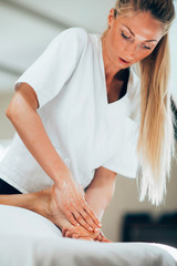 Fototapeta premium Pretty masseuse doing foot massage