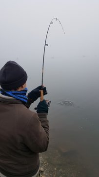pescatore al laghetto cattura un pesce