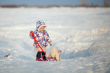Winter Walk of small pretty ruddy girl, child plays with soft toy