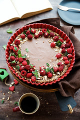 Raw vegan chocolate tart decorated with berries. Concept of healthy dessert
