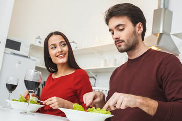 Young couple having romantic evening at home in the kitchen eating dinner