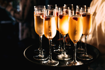 A close-up of glasses of champagne on a black tray