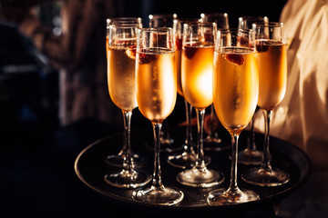 glasses of champagne on a dark tray with a small berry to celebrate