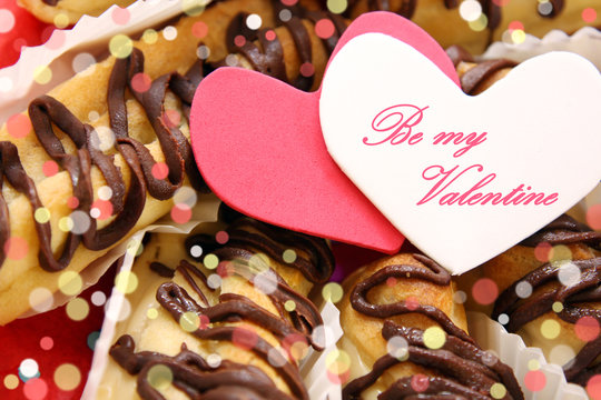 valentine's day concept, holiday greeting card - sweet love, breakfast for lover: eclairs and hearts on red festive background with greeting: be my valentine