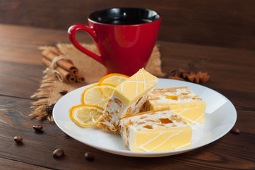 Cake on a plate with dried lemon on a wooden table