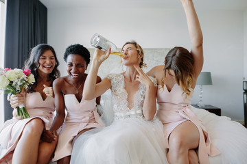 Bride and bridesmaids enjoying before wedding in hotel room - obrazy, fototapety, plakaty