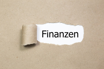 Finanzen (german for financial) written behind a torn paper