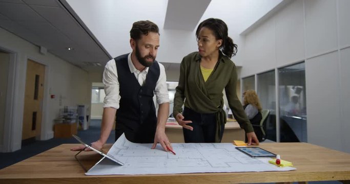 4K Architects or engineers collaborating on a project & discussing building design. Slow motion.