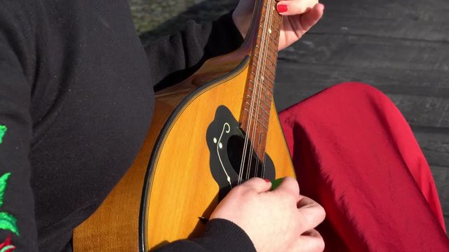 Woman wearing red dress playing mandoline