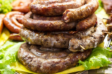 Freshly cooked sausages on a grill close-up. A background of sausages cooked on charcoal.