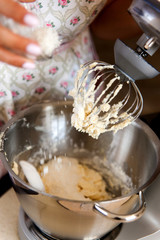 Female hands add the ingredient for baking in the bowl of a food processor.