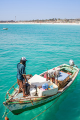 Fishermen on an old fishing boat at the pier and coast of Santa Maria, Sal, Cape Verde