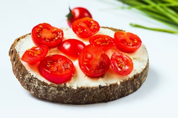 Bread with cherry tomato and cheese spread.
