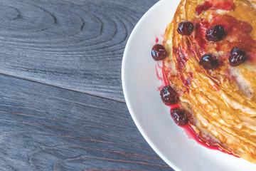 Maslenitsa pancakes with syrup on plate on dark gray wooden table. Healthy breakfast concept. Close up. Flat lay. Top view with copy space.