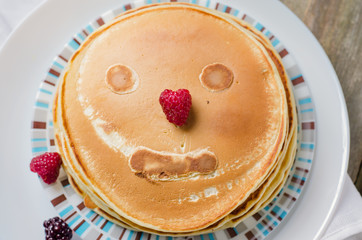 Photo of delicious pancakes with berries and honey over wooden tabe