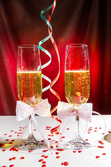 glasses of wine and serpentine on bright red background