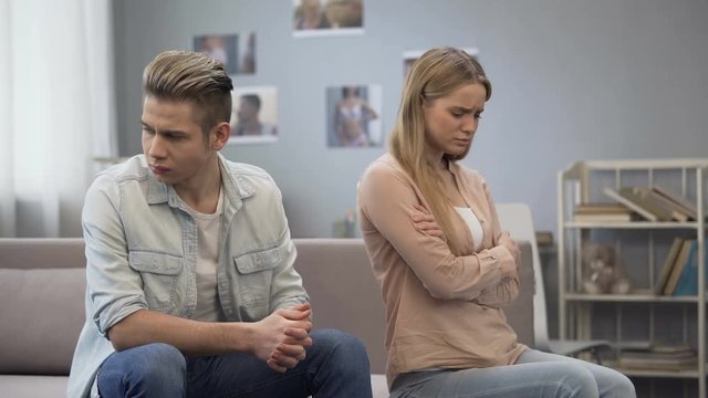 Upset girl looking hurt at guy waiting apology, difficulties in relationship