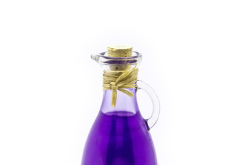 A neck of a bottle with purple oil on a white background