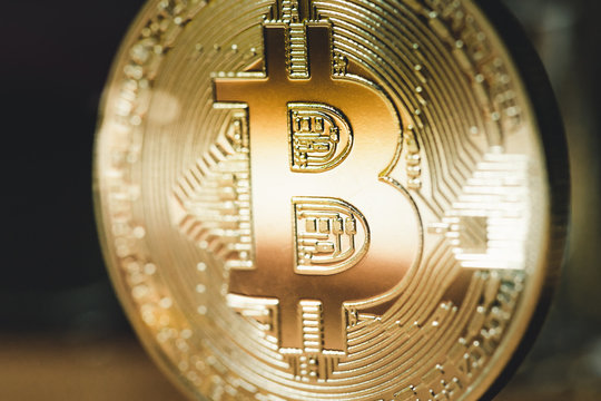 Golden Bitcoin on a dark background. Close up