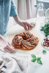 Pesto and dried tomatoes babka on white rustic background. Homemade bun. Traditional french cuisine. Selective focus