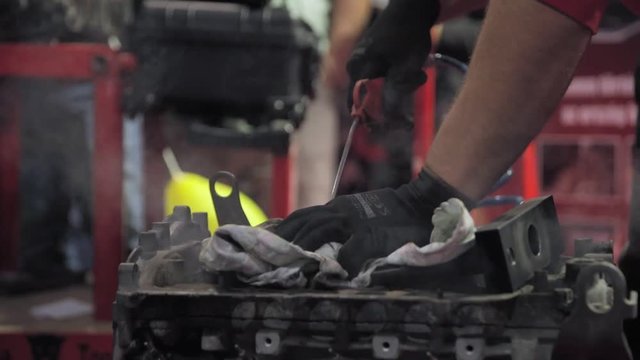 Hands of worker repairing an engine