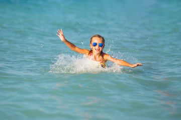 Cute young girl playing in the sea.  Happy pre-teen girl enjoys summer water and holidays in holiday destinations.