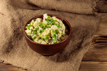 Traditional Russian festive salad Olivier on wooden table