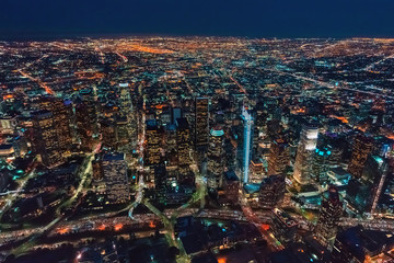 Fototapeta premium Aerial view of Downtown Los Angeles at twilight with young woman holding out a smartphone in her hand