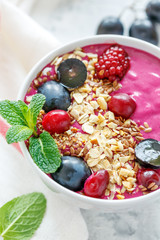 Red smoothie bowl with beets and black grapes.