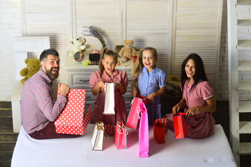 Man, woman and adorable children with gifts at home