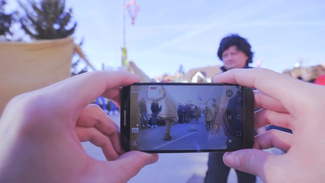 Taking out smartphone and record carnival parade 4K