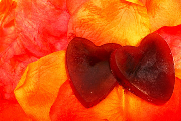 Heart shaped ice on artificial red and yellow petals