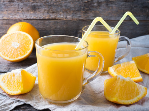 Fresh orange juice on wooden background, rustic style