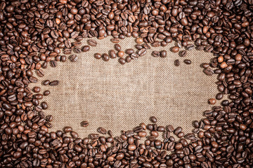 Background with frame of  roasted coffee grains macro close-up on burlap Food backdrop macro close-up