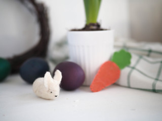 a little white toy Bunny on the table. Easter