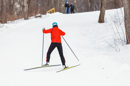 A young woman cross country skiing in forest