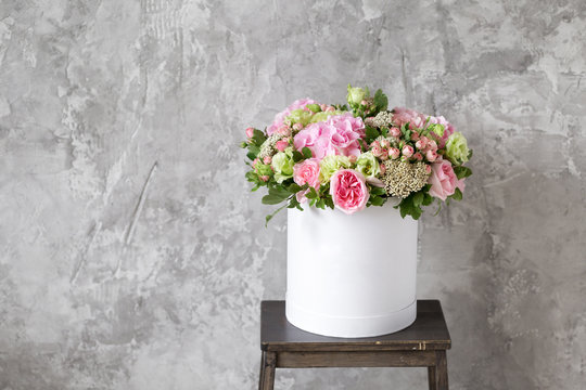 Fototapeta Beautiful tender bouquet of flowers in white box on gray ackground with space for text
