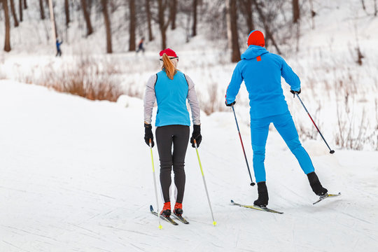 Two cross-country skiers training on a cross-country ski run in the forest