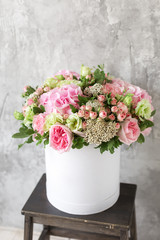 Beautiful tender bouquet of flowers in white box on gray ackground with space for text