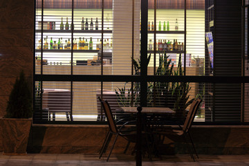 Modny bar w hotelu z barmanką, widok przez okno z żaluzjami - obrazy, fototapety, plakaty