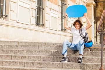 Happy teenage boy with blue blanked speech bubble