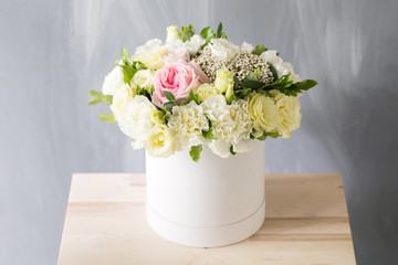 Beautiful tender bouquet of flowers in white box on light ackground with space for text