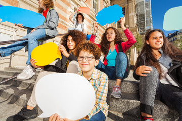 Cute teens with colorful empty speech bubbles