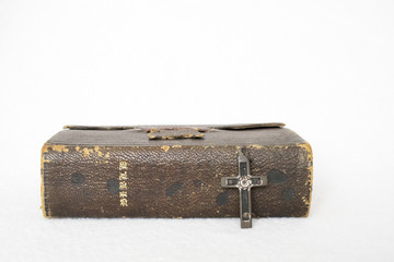 Antique Worn Leather Bible with Antique Cross Metal and Wood on White Background