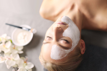 Face mask.Beautiful young girl at spa ,cosmetician woman applying facial mask