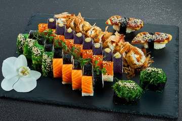 Sushi Set nigiri and sushi rolls on gray stone slate on metal background