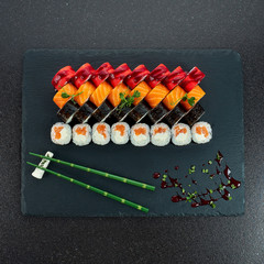 Sushi Set nigiri and sushi rolls on gray stone slate on metal background