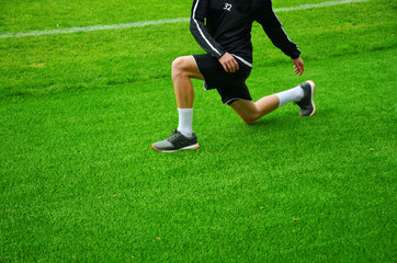 Stretching. Warm up on green grass